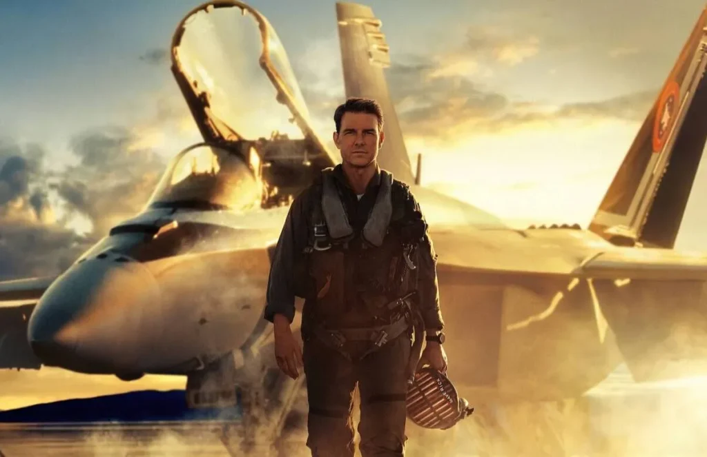 Tom Cruise como Maverick em cena do filme Top Gun Maverick com avião ao fundo
