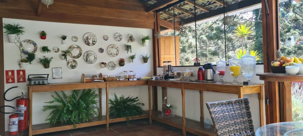 Área do café da manhã da Pousada Apple House em Campos do Jordão, com decoração aconchegante e vista para a natureza.
