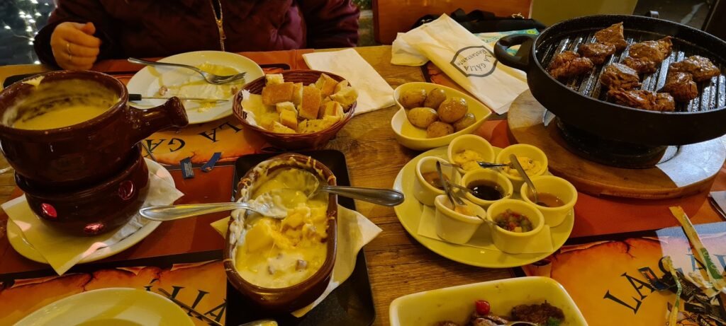 Fondue completo no Restaurante La Gália em Campos do Jordão, com carne na pedra, queijo e acompanhamentos.