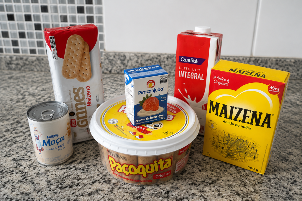 Ingredientes para pavê de paçoca simples e rápido sobre bancada de cozinha, com paçoca, leite condensado, creme de leite, leite, amido de milho e biscoito maisena.