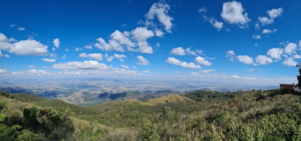 Vista do Pico do Itapeva em Campos do Jordão, com montanhas, céu azul e paisagem ampla ao fundo.