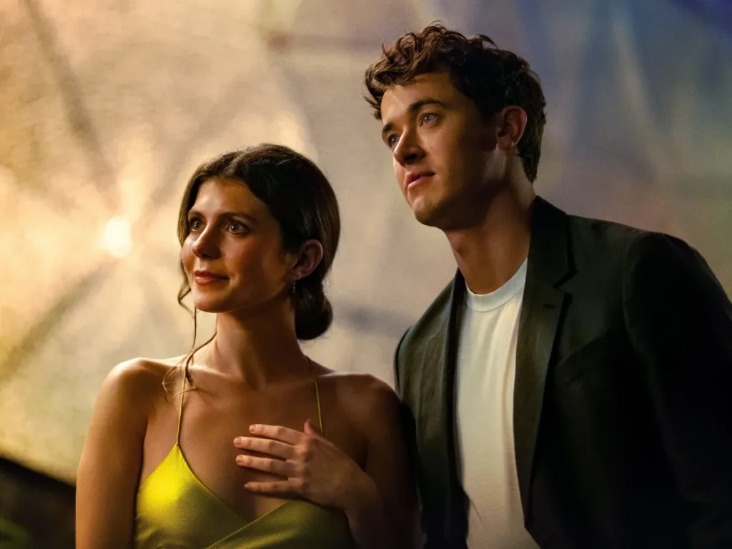 Poppy e Alex, interpretados por Emily Bader e Tom Blyth, juntos em uma cena noturna de De Férias com Você, da Netflix