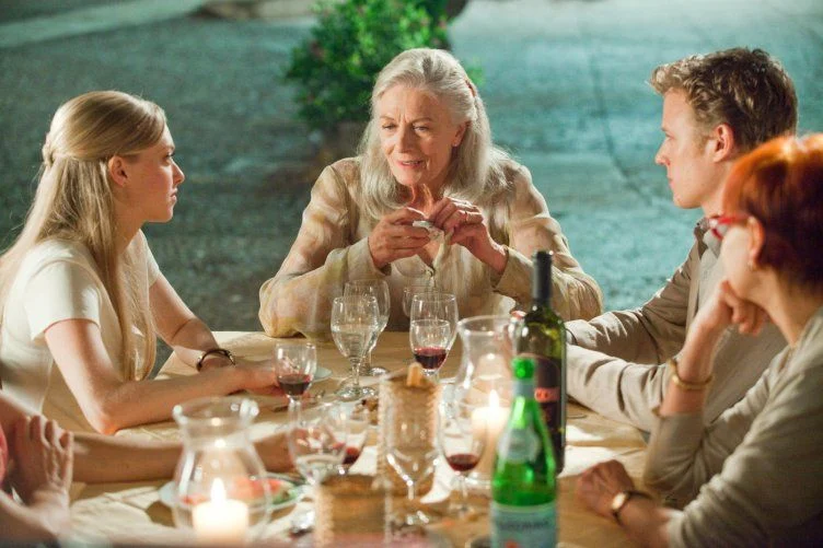 Cena de Cartas para Julieta com Claire, Sophie e Charlie reunidos à mesa durante a viagem pela Itália.