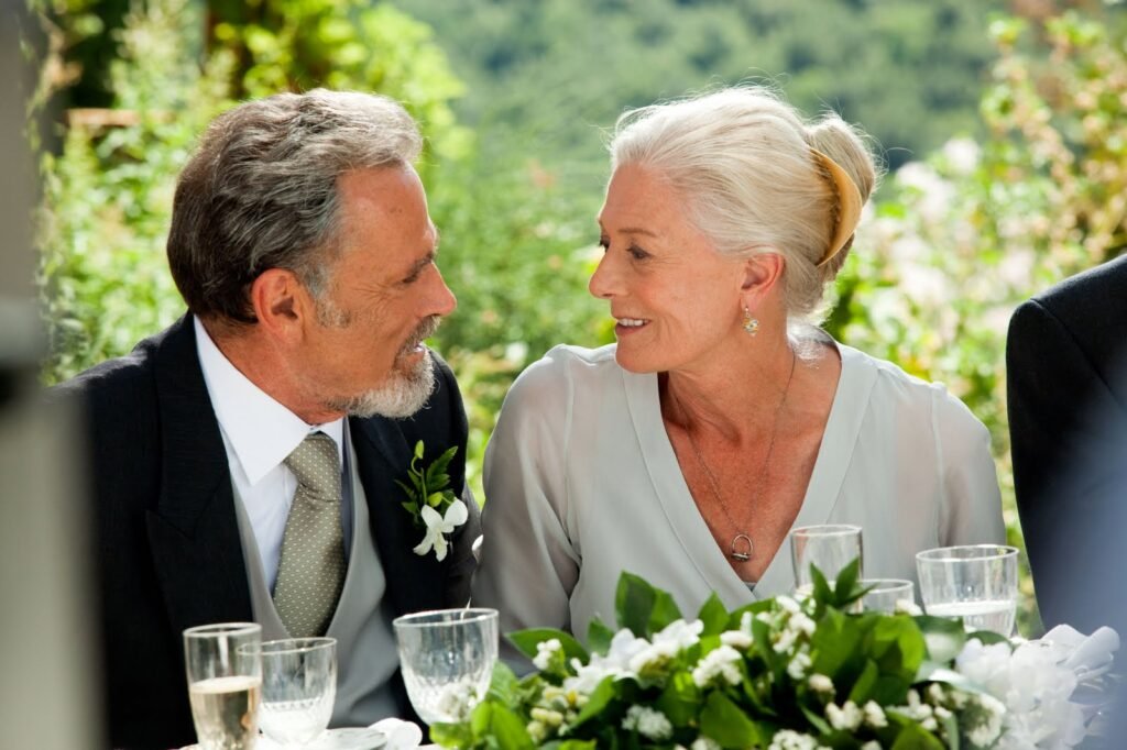Cena de Cartas para Julieta com Claire e Lorenzo no casamento, trocando um olhar carinhoso depois de se reencontrarem muitos anos mais tarde.